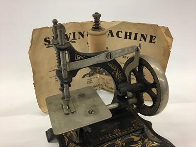 Lot 1879 - Miniature German  sewing machine and original instructions