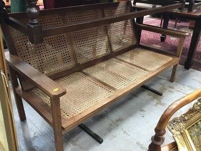 Lot 960 - Teak planters two seater bench with caned seat and back and matching elbow chair