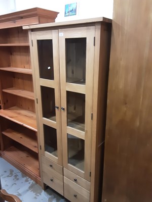 Lot 996 - Good quality contemporary light oak bookcase with shelved interior enclosed by two glazed doors, with four drawers below