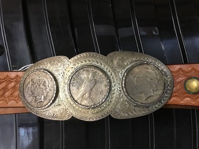 Lot 553 - A leather belt with buckle fitted three mounted silver dollars buckle