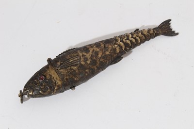 Lot 251 - Late 19th century white metal articulated model of a fish, with engraved decoration on body and tail, set with two red gem