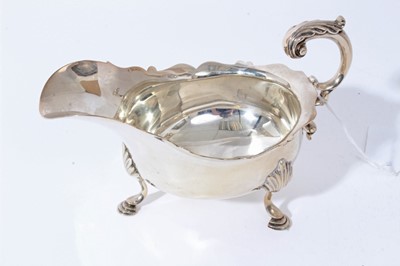 Lot 4 - Late Victorian silver sauce boat of conventional form with scroll handle, raised on three hoof feet, (London 1898), all at 7.5oz, 17.5cm from handle to spout.