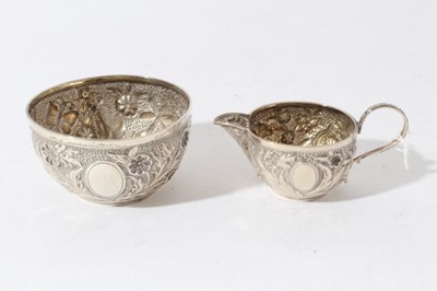 Lot 57 - Good quality Victorian silver cream jug with chased decoration depicting flowers and insects together with a matching sugar bowl, (Birmingham 1894), maker William Harrison Walter, all at 3.5oz (2)
