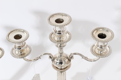Lot 114 - Pair of George VI silver candelabra, each with fluted columns and gadrooned borders, removable twin branches and three candle holders with removable sconces (Birmingham 1937)