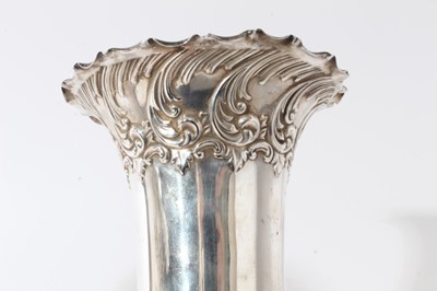 Lot 16 - Pair of Edwardian silver spill vases, with embossed decoration scroll decoration and flared rims, raised on circular pedestal (Sheffield 1902)