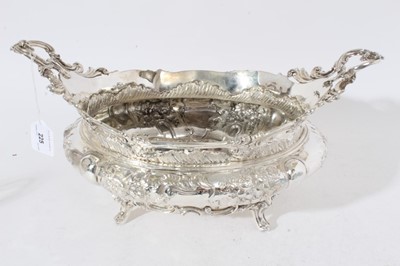Lot 225 - Impressive Edwardian silver table centre bowl of oval form with embossed floral and scroll decoration twin scroll handles and raised on four scroll feet, (London 1901)