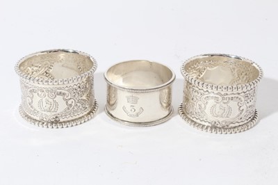 Lot 183 - Pair of late Victorian silver napkin rings with chased decoration and beaded borders, (Sheffield 1900), maker James Dixon and Sons, together with a Victorian silver napkin ring