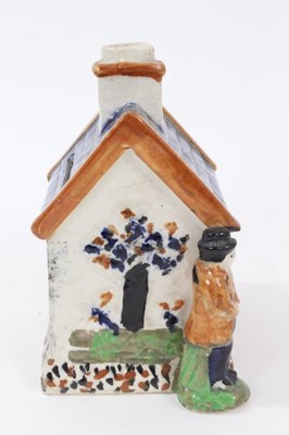 Lot 38 - Early 19th century Staffordshire Prattware money box, modelled as a house with figures on either side and faces peering out of the windows