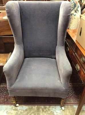 Lot 987 - Antique wing back armchair upholstered in blue material on turned mahogany legs with ceramic castors