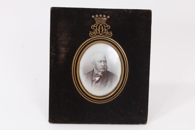 Lot 27 - Victorian memorial portrait photograph of an Earl in black enamel and gilt metal oval mount with Earls coronet and JD monogram cresting on velvet ground with gilt metal easel back, 18.6 x 16 cm