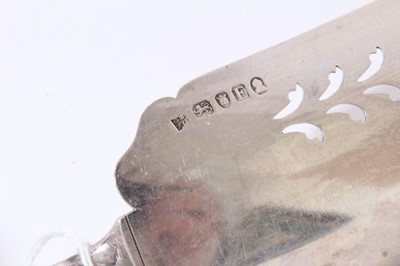 Lot 158 - George III silver fish slice with curved pierced blade and brite cut engraved decoration (London 1800), together with another similar (London 1787), 31 and 30cm in length (2)