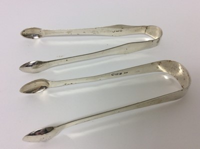 Lot 191 - Two pairs of Georgian silver sugar tongs, Victorian silver mounted and glass bodied inkwell, contemporary silver armada dish and a silver cigarette box of square form