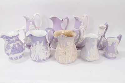 Lot 689 - Collection of nine 19th century relief moulded lilac-ground jugs, mostly Samuel Alcock, including the Portland Jug, Naomi and her Daughters in Law, etc, the largest measuring 29cm height