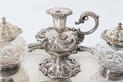 Lot 157 - Victorian silver inkstand of oval form, with shell, scroll and leaf border, central chamberstick with snuffer and a pair of cut glass inkwells with silver mounts, on four scroll feet (London 1891)