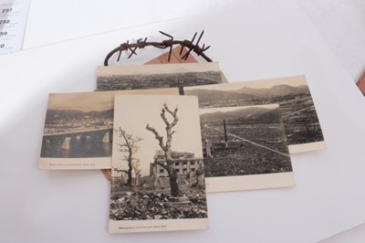 Lot 254 - Group of five postcards showing the damage caused by the Atomic bomb at Hiroshima together with other cards and a piece of First World War barbed wire