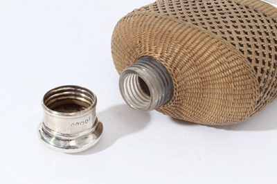 Lot 86 - Victorian silver mounted glass hip flask with silver screw fit top, (London 1868) wicker covered body and silver plated detachable cup with gilded interior, 15.5cm in length