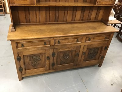 Lot 195 - Good quality carved oak dining room suite comprising refectory table on pierced end standards 211 x 103 cm, eight chairs with tapestry seats, oak sideboard with armorial lion decoration116 cm
