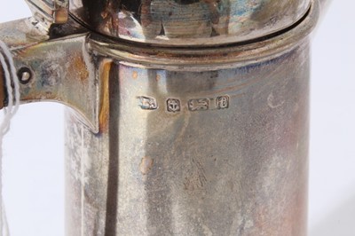 Lot 146 - George V silver hot water pot of tapered cylindrical form, domed hinged cover with turned wood finial and angular bakelite handle, (Birmingham 1918) together with a silver topped