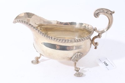 Lot 108 - Victorian silver sauce boat with gadrooned border on three scroll legs with shell feetLarge Victorian silver sauce boat of helmet form with engraved armorial, gadrooned border and scroll handle
