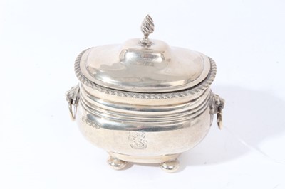 Lot 107 - Edwardian silver tea caddy of oval cauldron form with reeded bands and and engraved armorial, domed hinged cover with gadrooned border, raised on four bun feet, (Chester 1906)
