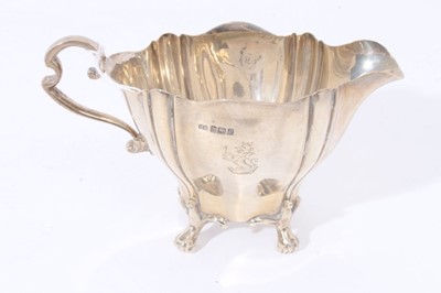 Lot 109 - Edwardian silver two handled sugar bowl with fluted decoration, engraved armorial and scroll handles, raised on four scroll feet, together with a matching milk jug, (Sheffield 1906)