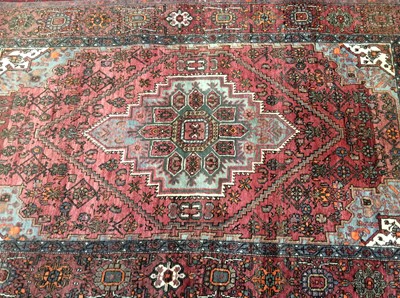 Lot 925 - Eastern rug with geometric decoration on red ground. 207cm x 127cm