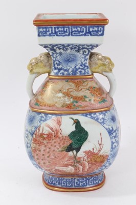Lot 142 - Antique Japanese Meiji period porcelain vase, painted in the Satsuma style with panels containing peacocks, landscape scenes and dragons, on an underglaze blue ground, with beast mask handles, 29cm...