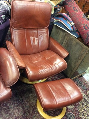 Lot 1036 - Contemporary brownish red leather revolving reclining armchair with matching footstool