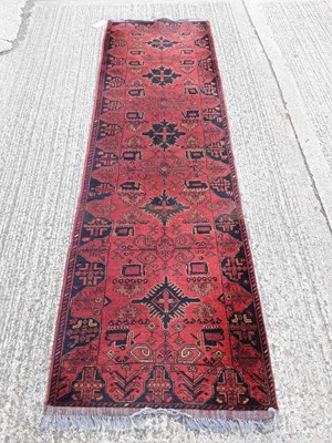 Lot 1065 - Eastern runner with geometric decoration on red and blue ground, 277cm x 84cm