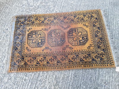 Lot 1068 - Eastern rug with geometric decoration on gold and black ground, 138cm x 91cm