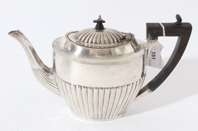 Lot 151 - George V silver four piece tea set, comprising teapot of half fluted form, with angular ebony handle and hinged domed and fluted cover, with carved ebony finial, on an oval base, matching sugar an...