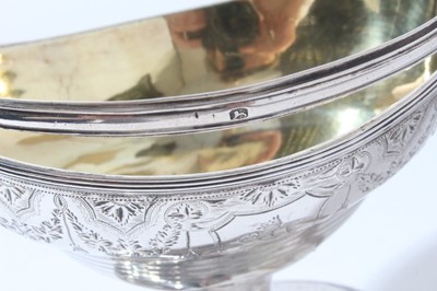 Lot 185 - George III silver sugar basket of navette form with brite cut engraved decoration, engraved armorial, swing handle with gilded interior, raised on oval pedestal foot, (London 1794), maker H S, all...