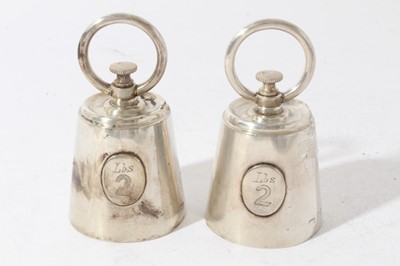 Lot 187 - Pair of unusual Edwardian novelty pepper grinders in the form of 2lb Bell weights, with engraved armorials and circular paniels marked 'lbs 2', (London 1902), maker Mappin & Webb, each 10.5cm in he...