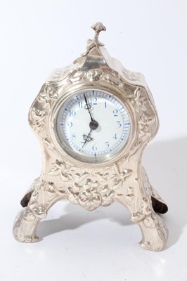 Lot 191 - Edwardian Art Nouveau silver mantel clock in a decorative case with embossed floral and foliate decoration, hinged rear door, raised on four legs, (London 1907), maker William Comyns, 16.5cm in ove...