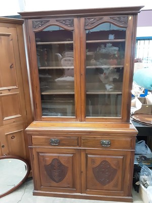 Lot 1083 - Late 19th / early 20th century mahogany two height bookcase with shelved interior enclosed by two glazed doors, two drawers and two carved panelled doors below, 119cm wide, 42cm deep, 203cm high