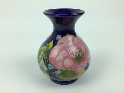 Lot 70 - Moorcroft pottery vase decorated in the Magnolia pattern on blue ground, impressed marks to base, 13cm high