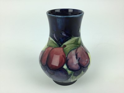 Lot 71 - Moorcroft pottery vase decorated in the Wisteria pattern on blue ground, impressed marks and blue painted signature to base, 12.5cm high