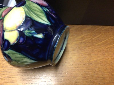 Lot 71 - Moorcroft pottery vase decorated in the Wisteria pattern on blue ground, impressed marks and blue painted signature to base, 12.5cm high