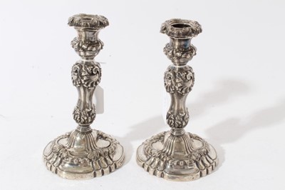 Lot 253 - Pair of George IV silver candlestick with fluted and scroll decoration on circular bases with engraved armorials, with urn shaped candle holders and removable sconces, (Sheffield 1824), maker John...