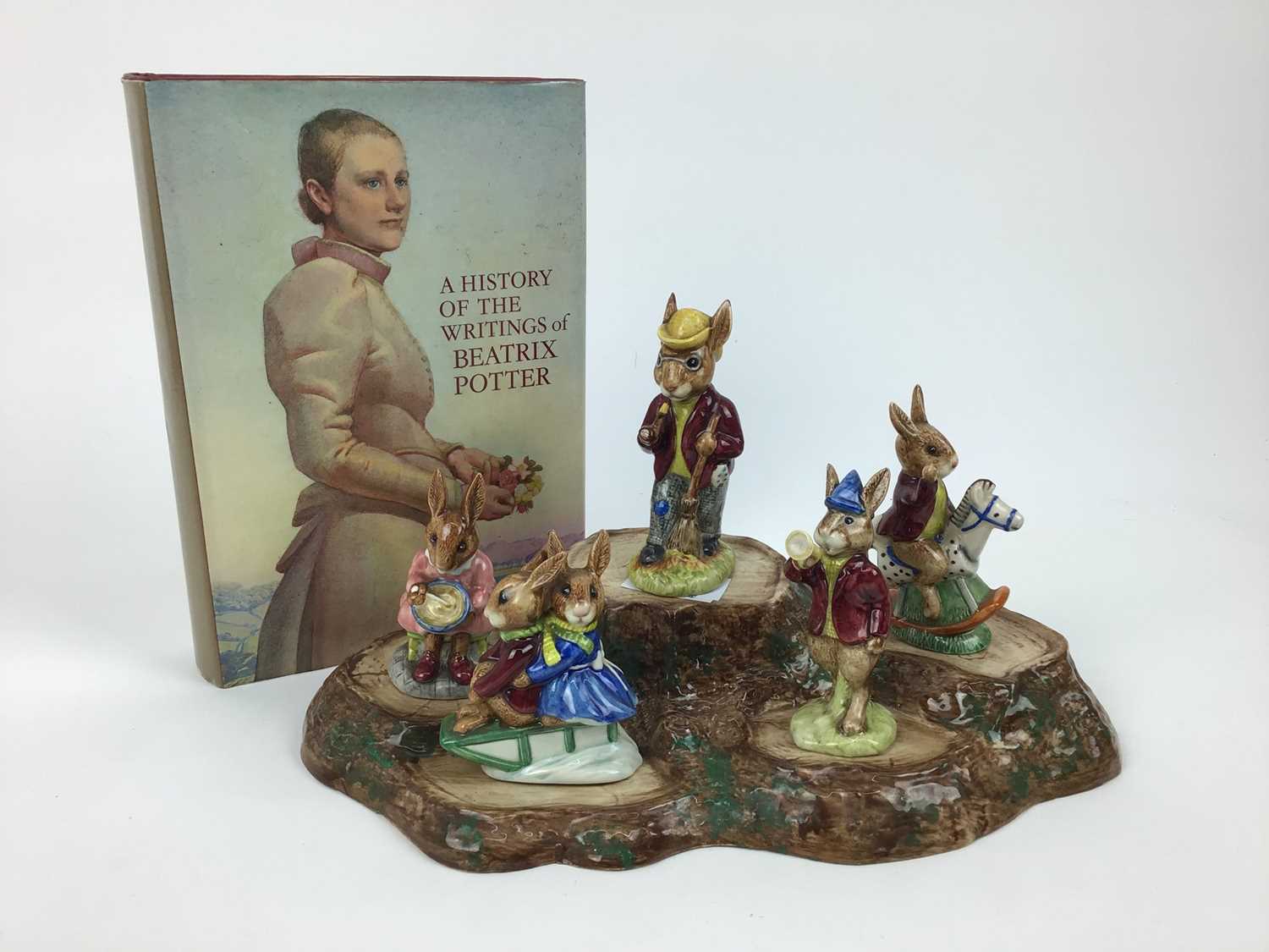 Lot 183 - Five Royal Doulton Bunnykins figures - Mr Bunnykins, Buntie, Rise and Shine, Sleigh Ride and Tally Ho, Beswick stand and a book - A History Of The Writings of Beatrix Potter