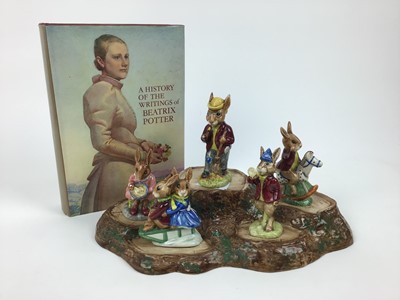 Lot 149 - Five Royal Doulton Bunnykins figures - Mr Bunnykins, Buntie, Rise and Shine, Sleigh Ride and Tally Ho, Beswick stand and a book - A History Of The Writings of Beatrix Potter