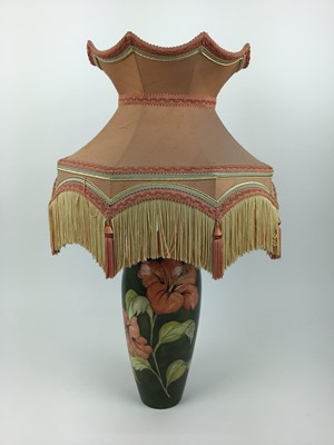 Lot 197 - Moorcroft pottery table lamp decorated in the Hibiscus pattern on green ground, impressed marks to base and original paper label - Potters To The Late Queen Mary, 31.5cm high excluding the fittings