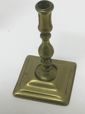 Lot 68 - Pair of early 18th century brass squat candlesticks, together with a similar taperstick