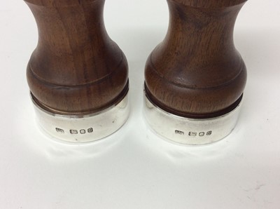 Lot 176 - Pair of silver mounted pepper mills with turned waisted wooden bodies (London 1976), 10.5cm high