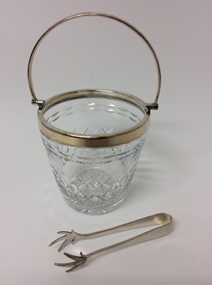 Lot 178 - Good quality cut glass ice bucket with silver plated mounts and swing handle, together with a pair of silver plated tongs with claw-shaped bowls, 25cm high overall