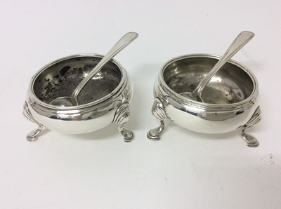 Lot 181 - Pair of George II silver cauldron salts with reeded borders and three hoof feet, marks indistinct, circa 1759, together with a pair of Victorian silver bead pattern salt spoons (London 1869), all a...