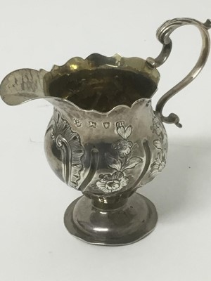 Lot 153 - Early George III silver cream jug, maker AISN, London 1767, with fluted rim and embossed floral wrythen ornament, 11cm high