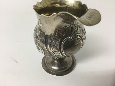 Lot 153 - Early George III silver cream jug, maker AISN, London 1767, with fluted rim and embossed floral wrythen ornament, 11cm high