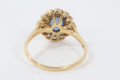 Lot 27 - Sapphire and diamond cluster ring with an oval mixed cut blue sapphire measuring approximately 7.75mm x 5.75m x 2.8mm surrounded by twelve brilliant cut diamonds on 18ct yellow gold shank. Estimate...