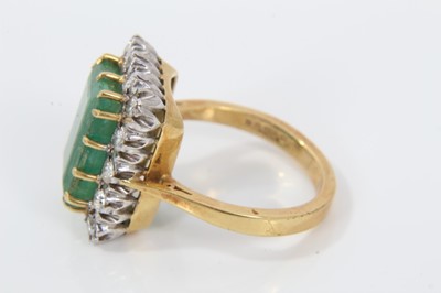 Lot 32 - Emerald and diamond cluster ring with a rectangular step cut emerald measuring approximately 12.85mm x 8.75mm x 5mm, surrounded by a border of brilliant cut diamonds in claw setting on 18ct gold sh...